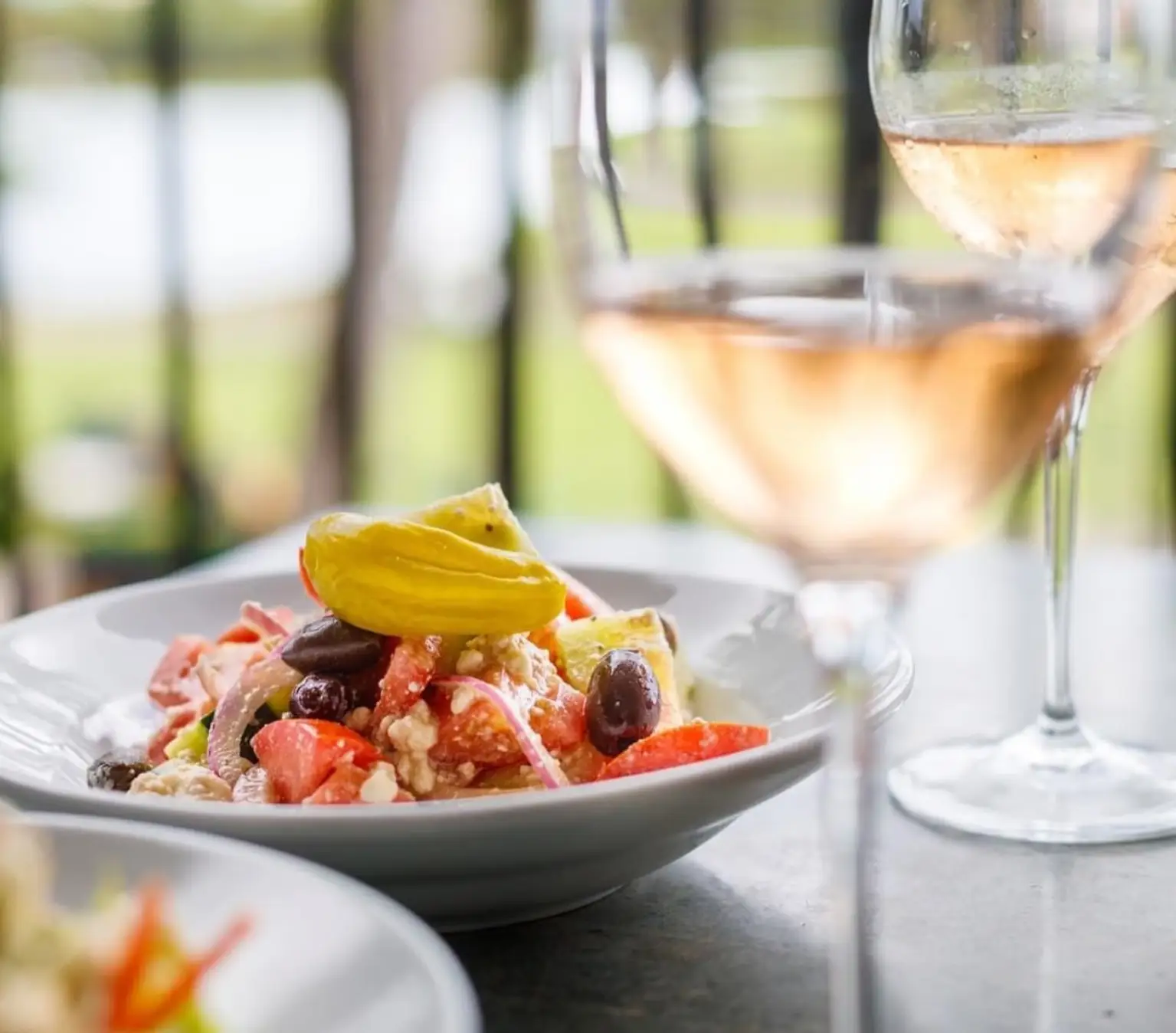 Greek salad with tomato, cucumber, feta, romaine, red onion, Kalamata olives, and Greek dressing served at Manoli’s Pizza Company in Wailea Maui.